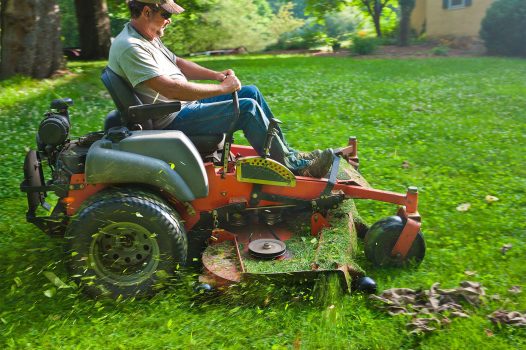 Landscaper cutting grass on riding lawn mower